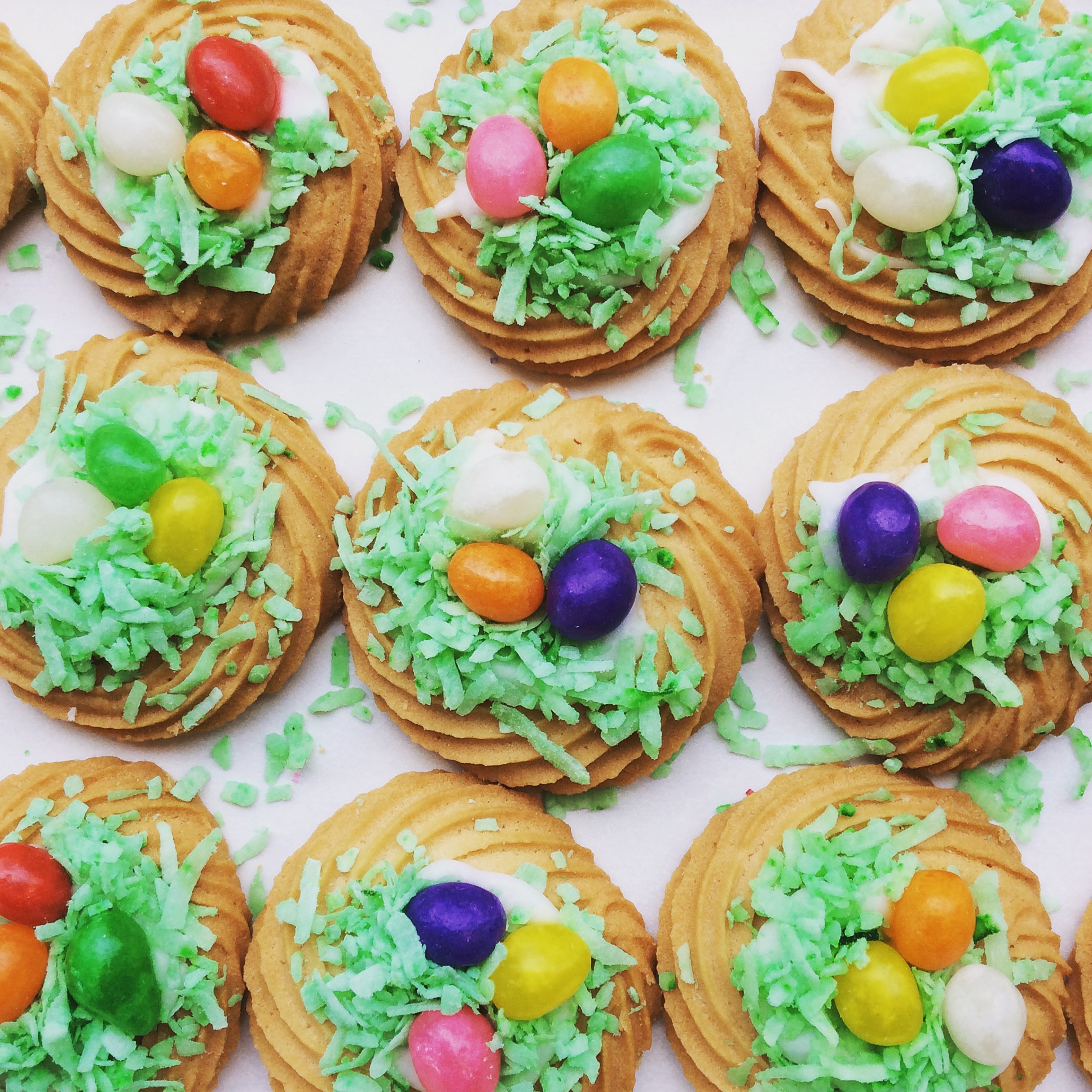 Rows of Easter butter cookies, decorated with icing, green coconut, and jellybeans.