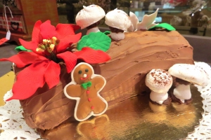 Christmas Yule log (Buche de Noel) decorated with sugar poinsettia and meringue mushrooms.